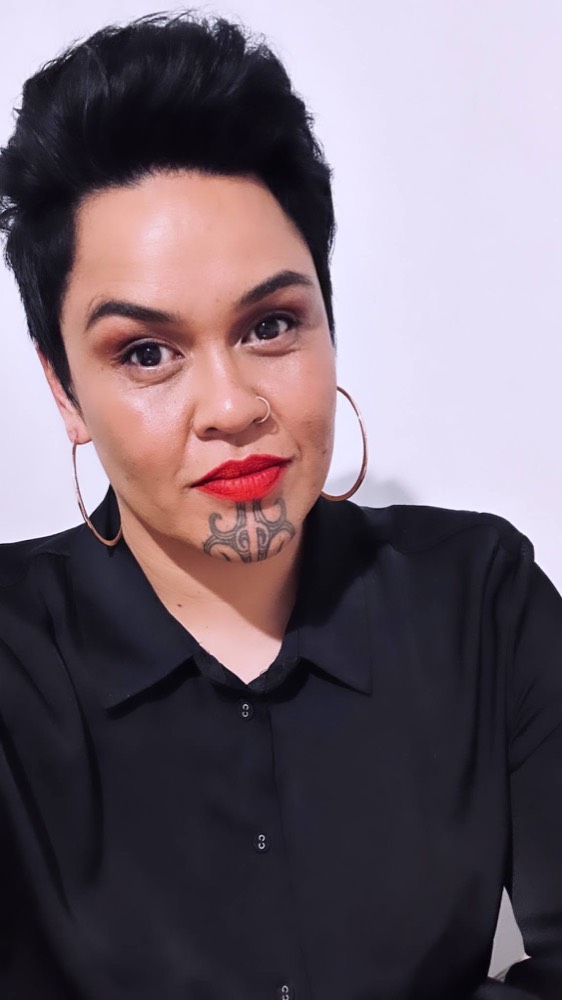 Pepa Pomana, curly hair artist and owner of Curl Native Studio, wearing a black shirt and gold hoops